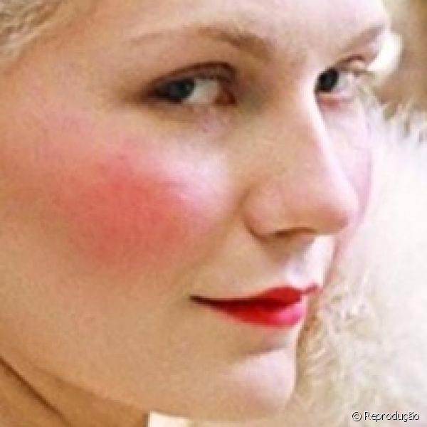 Os tons de vermelho ganharam destaque no blush e no batom usados por Kirsten Dunst em 